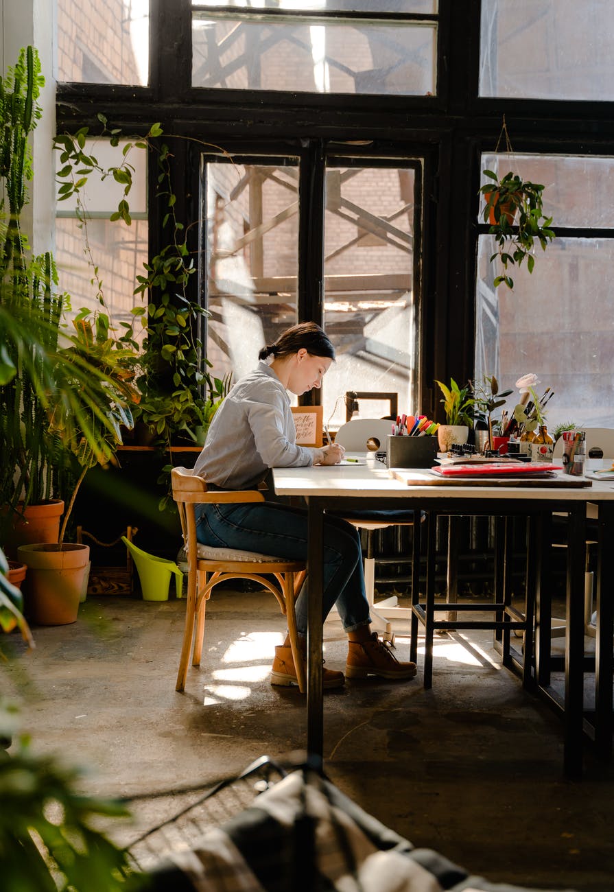photo of woman sitting by the table while writing authentic creative marketing